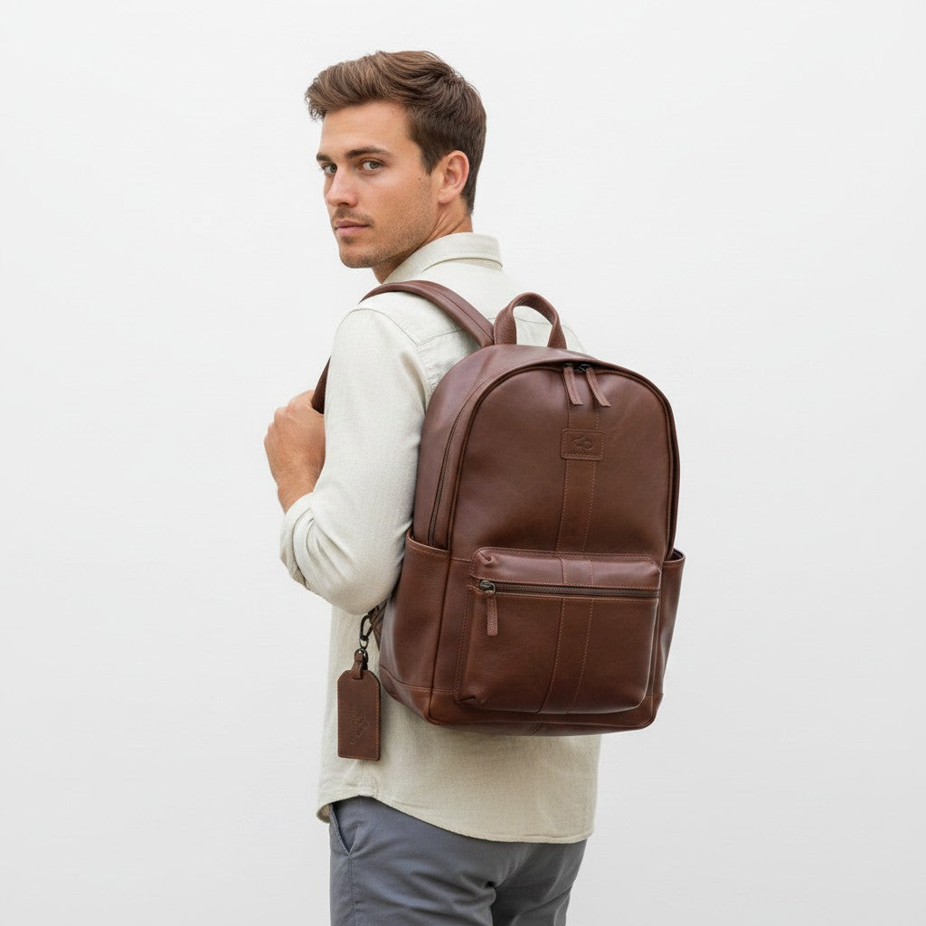 Chris Louis warm brown genuine leather backpack with front zip pocket, side pockets, and detachable luggage tag.
