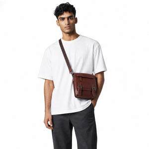 Chris Louis brown genuine leather crossbody travel bag with double roller buckle closure and adjustable strap.