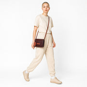 Chris Louis brown leather crossbody wallet with orange strap and trim, featuring a flap closure and embossed logo.