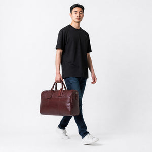 Chris Louis genuine brown leather duffle bag with top handles and detachable shoulder strap. Features exterior zip pocket and luggage tag.