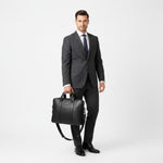 Chris Louis Difa black full grain leather office bag with top handles and detachable strap, carried by a woman in a blazer.