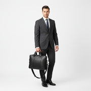 Chris Louis Difa black full grain leather office bag with top handles and detachable strap, carried by a woman in a blazer.