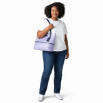 Chris Louis light lavender faux leather tote bag with navy blue trim and straps, zip-top closure and exterior zip pocket.