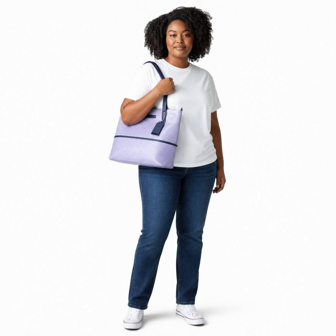Chris Louis light lavender faux leather tote bag with navy blue trim and straps, zip-top closure and exterior zip pocket.