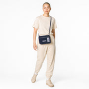 Chris Louis Isfahan Crossbody Bag in deep navy leather with light grey stitching and strap. Features flap closure and metal logo.