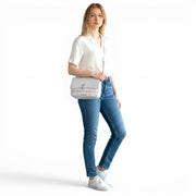 Chris Louis Ketty crossbody bag in light grey polyurethane with a plaid front flap and silver hardware, worn by a model.