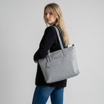 Chris Louis light grey pebbled leather tote bag with zip-top closure and adjustable straps.