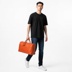 Chris Louis orange leather duffle bag with ribbed panel detail and luggage tag. Perfect for weekend travel.