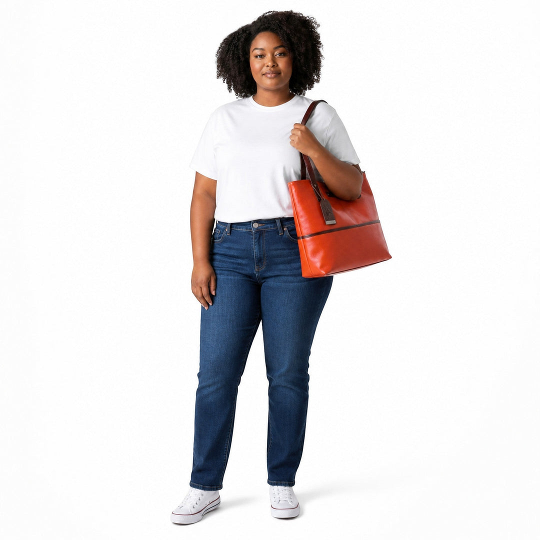 Chris Louis orange leather tote bag with dark brown trim and straps, featuring a hanging leather tag and polished hardware.