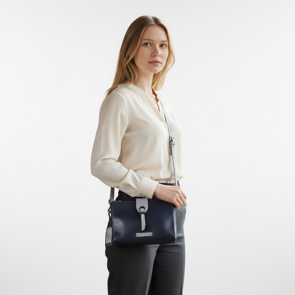 Chris Louis Santorini Leather Cross Body bag in black/grey with front flap and metal hardware, worn by a woman.
